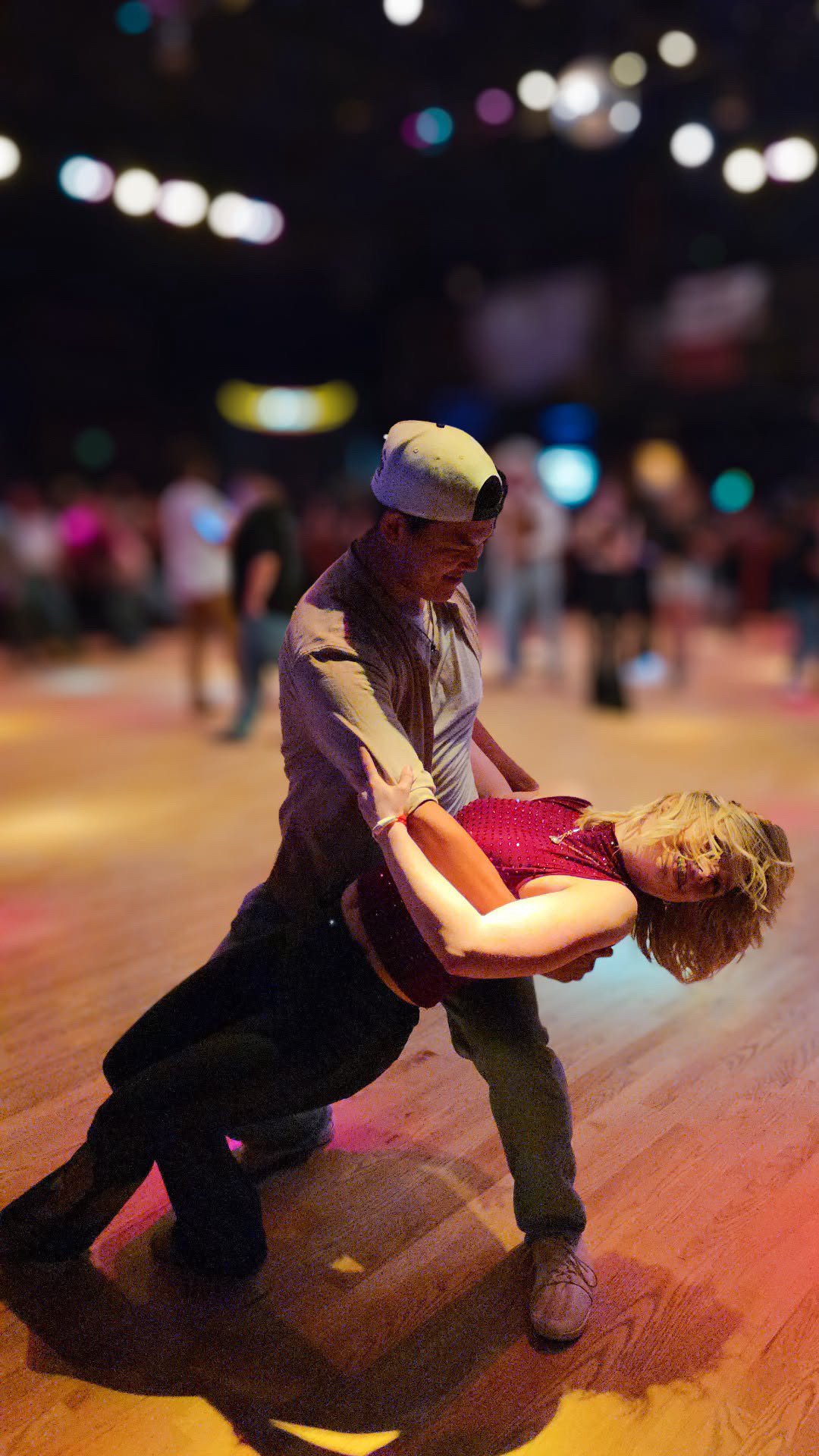 Nolan dipping his partner on the dance floor at a country dance hall