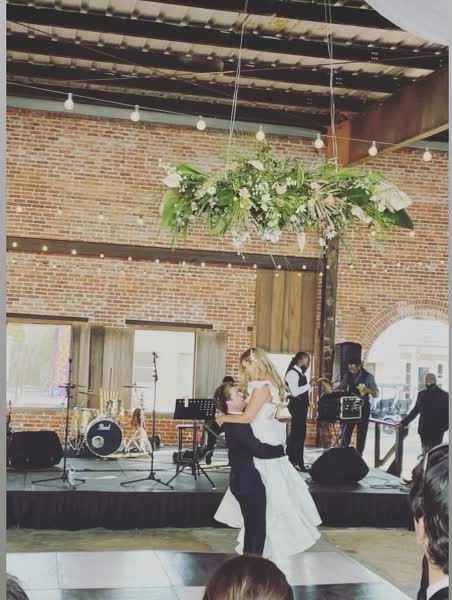 Couple dancing beneath suspended florals